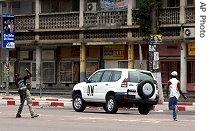 Two men throw stones at a UN car as they run after it in the streets of Kinshasa, Aug. 21, 2006<br /><br />